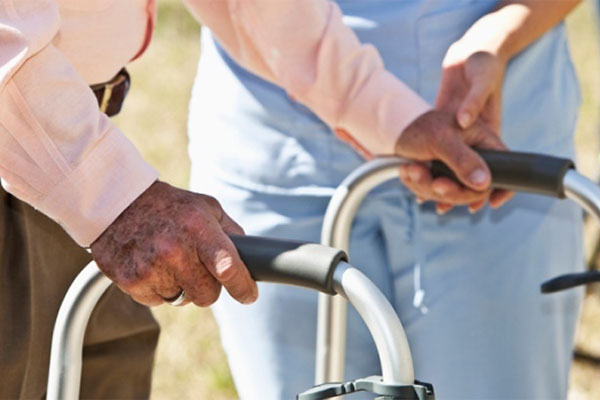 A Nurse Helping The Old Man To Walk Using His Walker - Home Care Packages - ESP Healthcare