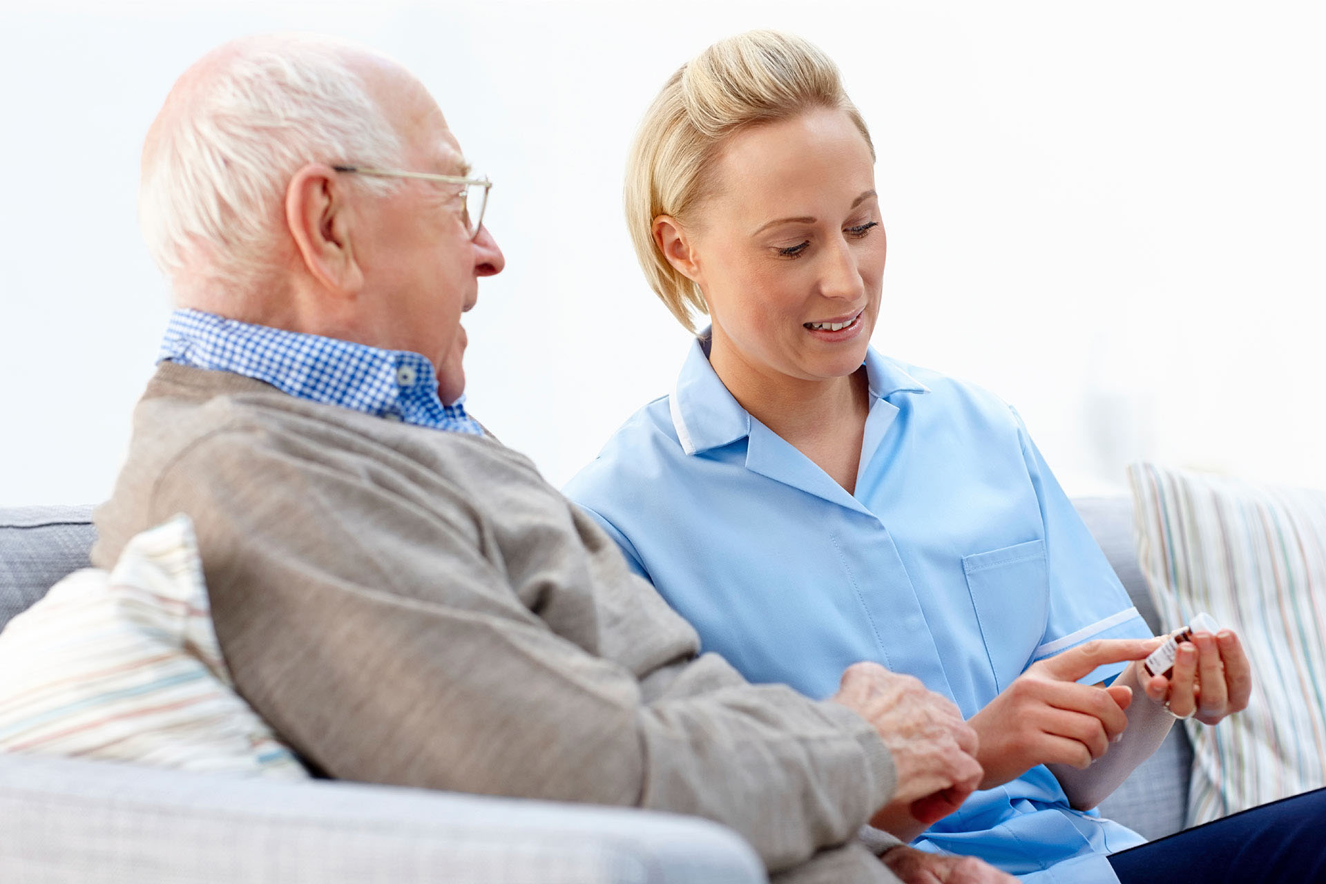 Female Caregiver Explaining To The Elderly Man His Medication - Home Care Packages - ESP Healthcare