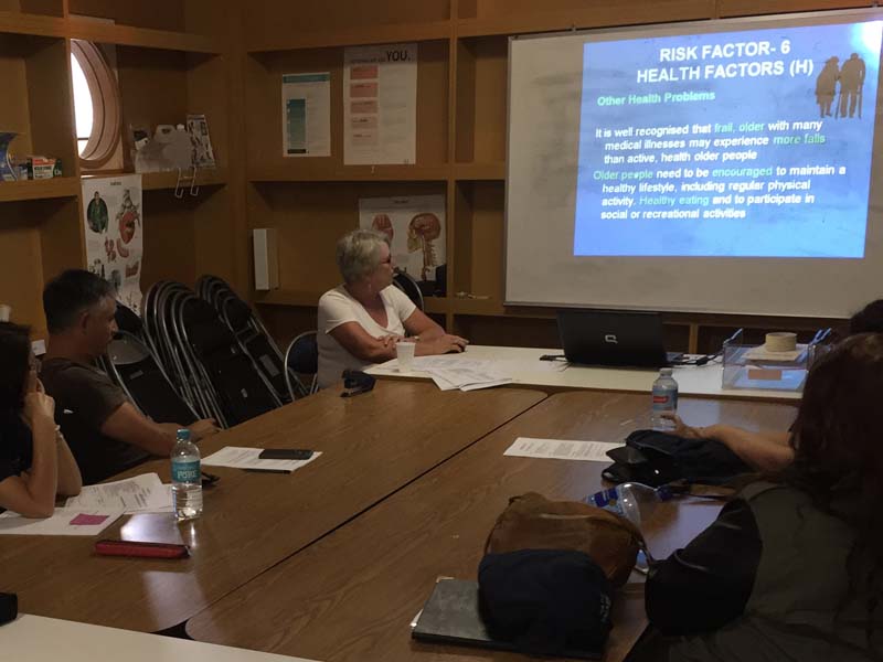 A Group Of People Sitting Around Looking At a Presentation - Sydney Home Care - ESP Healthcare