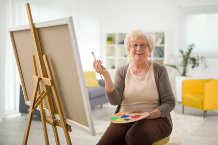Happy Older Woman Holding A Paint Brush - In Home Aged Care - ESP Healthcare
